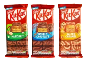 Three packages of Nestlé Kit Kat bars featuring Hazelnut, Double Chocolate, and Salted Caramel flavors, all labeled as new.