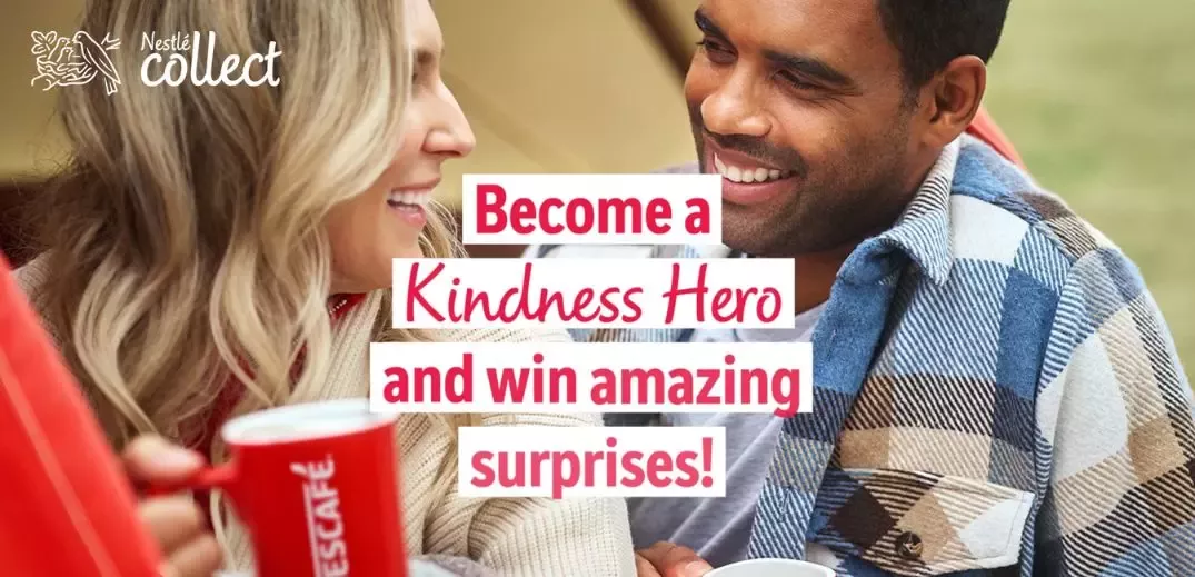 A woman and a boy sit together, holding cups, with text promoting a "Kindness Hero" initiative for winning surprises.